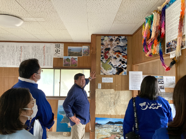 【豊島のこころ資料館】汚染された地下水について当時の写真を見ながら説明を受ける様子