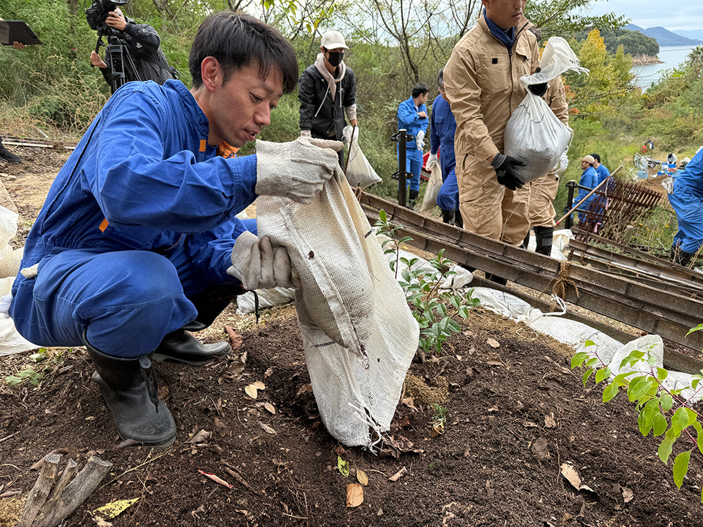 集めた土を植樹地に撒く様子2
